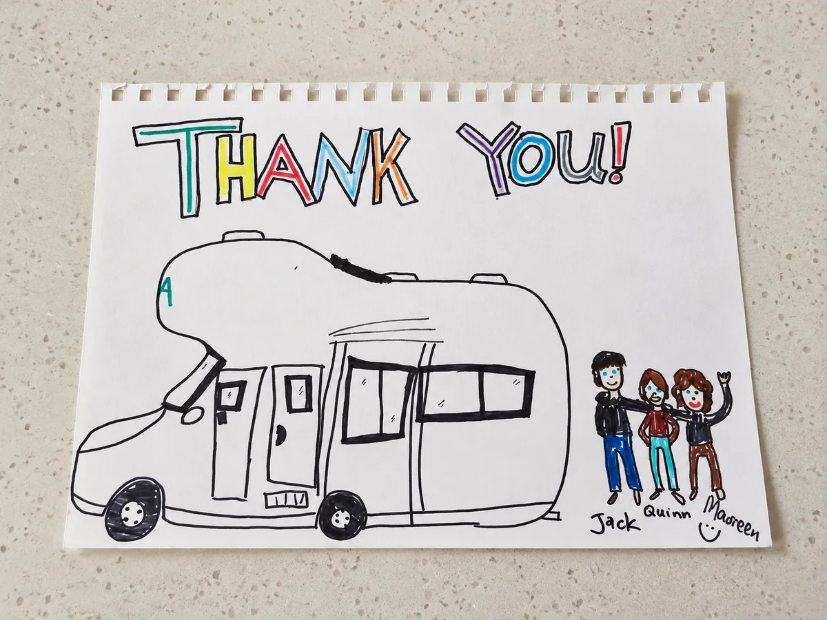 A child’s handmade thank-you drawing of a motorhome and three travellers